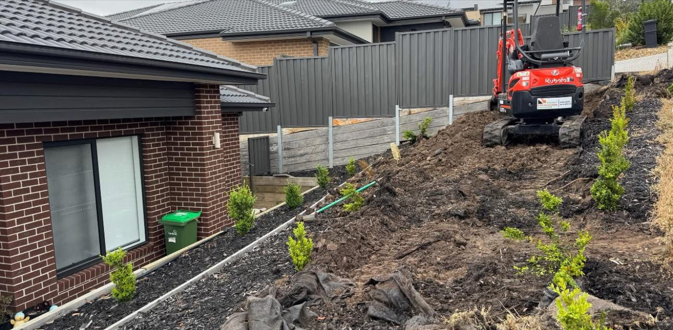 Our excavator cutting into a sloped block behind a new home