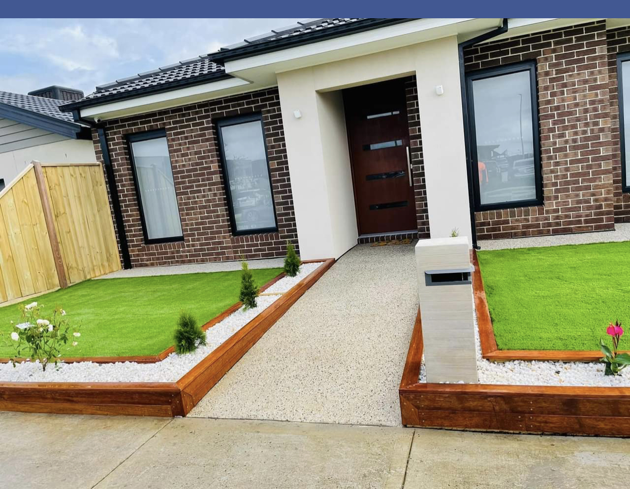Front yard with new turf, white pebble beds and stained timber edging