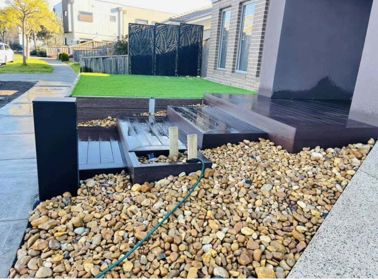 Timber deck with a built feature step and river pebble bed